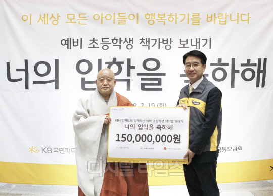 19일 '예비 초등학생 책가방 보내기'행사에서 이동철 KB국민카드 사장(오른쪽)이 재단법인 아름다운 동행의 이사장인 원행 스님에게 다음달 초등학교 입학 예정인 어린이들을 위한 1억 5000만원 상당 책가방 선물 세트를 전달하고 있다. KB국민카드 제공.